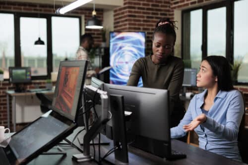 Two women work on endpoint protection security at desk